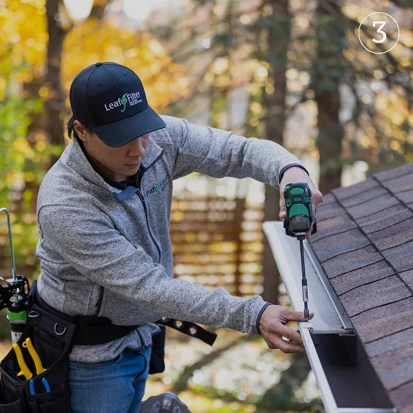 LeafFilter employee installing LeafFilter gutter guards on a home